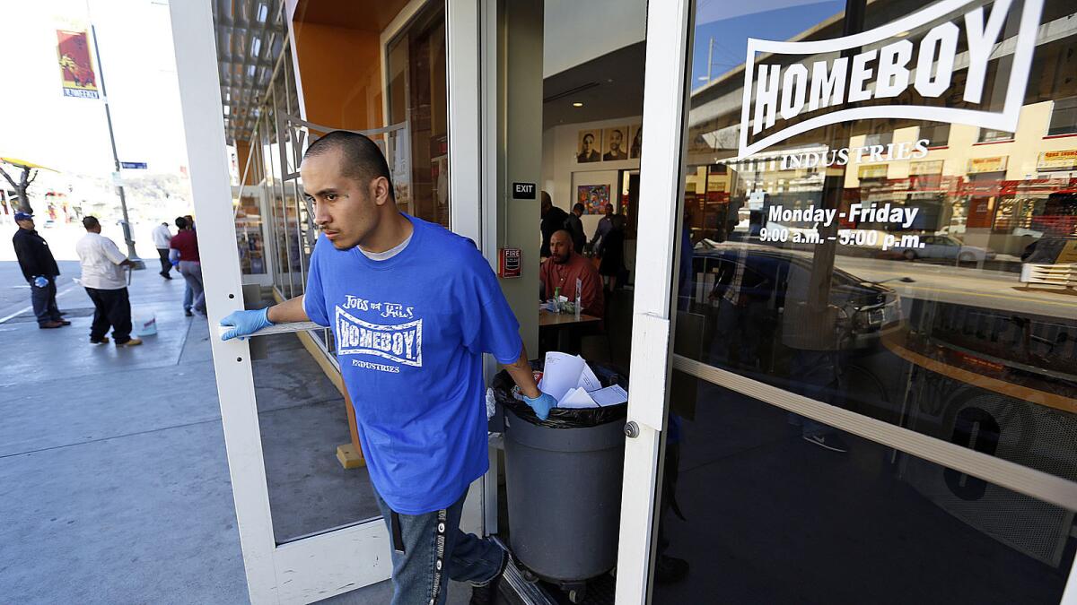 LOS ANGELES, CA - MARCH 5, 2015: Garai Bastida takes out garbage working at the 130 W. Bruno St. headquarters of Homeboy Industries on March 5, 2015 which is near the site of a Homeboy Industries expansion into a neighboring building scheduled to open in April. (Al Seib / Los Angeles Times)