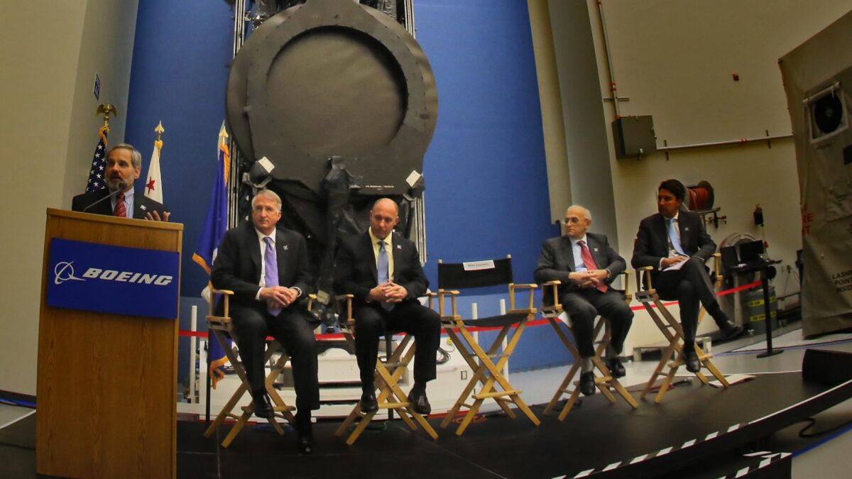 Boeing executive Mike Connelly, left, unveils the world’s first all-electric-propulsion satellites at Boeing’s El Segundo satellite division in January.