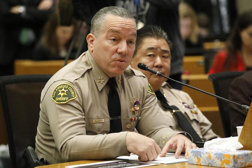 LOS ANGELES, CA - OCTOBER 01, 2019 Los Angeles County Sheriff Alex Villanueva, left, seated with Undersheriff Tim Murakami, second-in-command addresses the Los Angeles County Board of Supervisors meeting to proposals regarding spending at the SheriffÕd Department in an effort to recover a $63 million budget deficit. (Al Seib / Los Angeles Times)