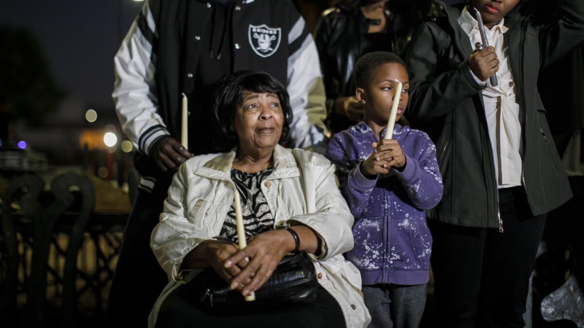 Ruth Harlins, seated, is joined by family and community members at a candlelight vigil for her daughter Denise Harlins in Los Angeles on Wednesday. Denise Harlins died this week.