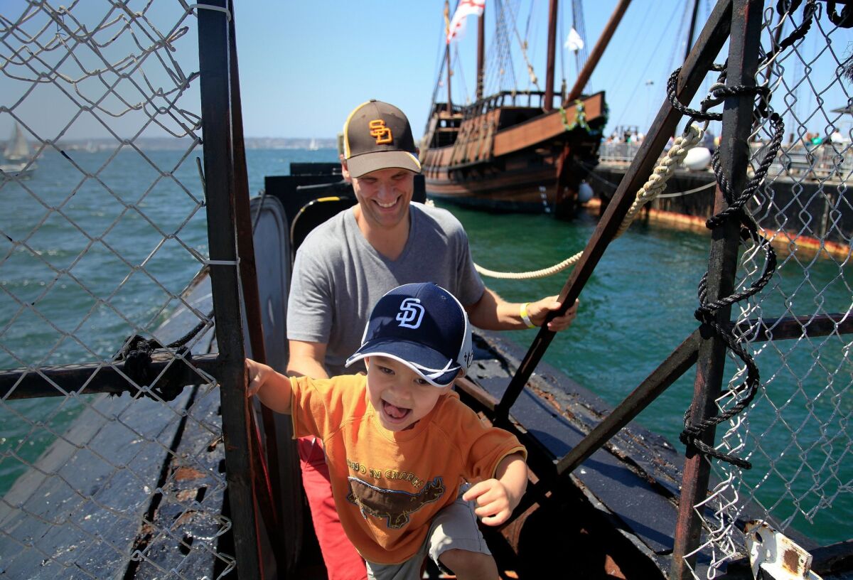 Bennett Renger, 2, and Andy Renger of San Diego emerge from touring the B-39 Submarine at the Festival of Sail Saturday. — Misael Virgen