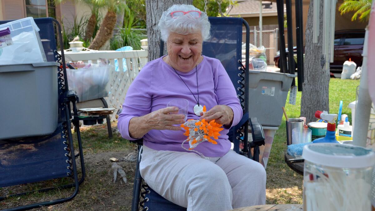 Costa Mesa resident Mary Spadoni untangles a string of her 3,000-light collection used in decorating her Orange Avenue home.