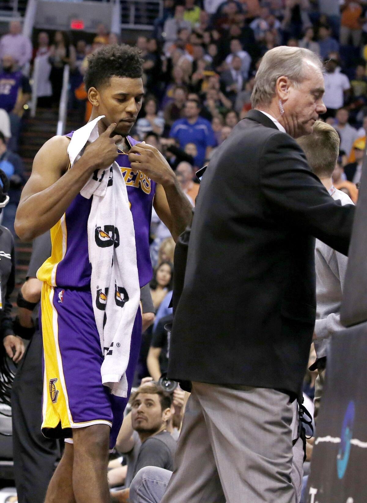 Lakers small forward Nick Young is escorted from the court after being involved in a scuffle during the first half of Wednesday's game against the Phoenix Suns.