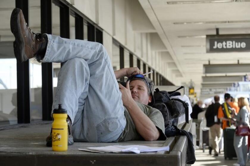 A stranded traveler, James Rusk of Fort Collins, Colo., waits for operations to get back to normal Saturday so he can take a flight out of Los Angeles International Airport.