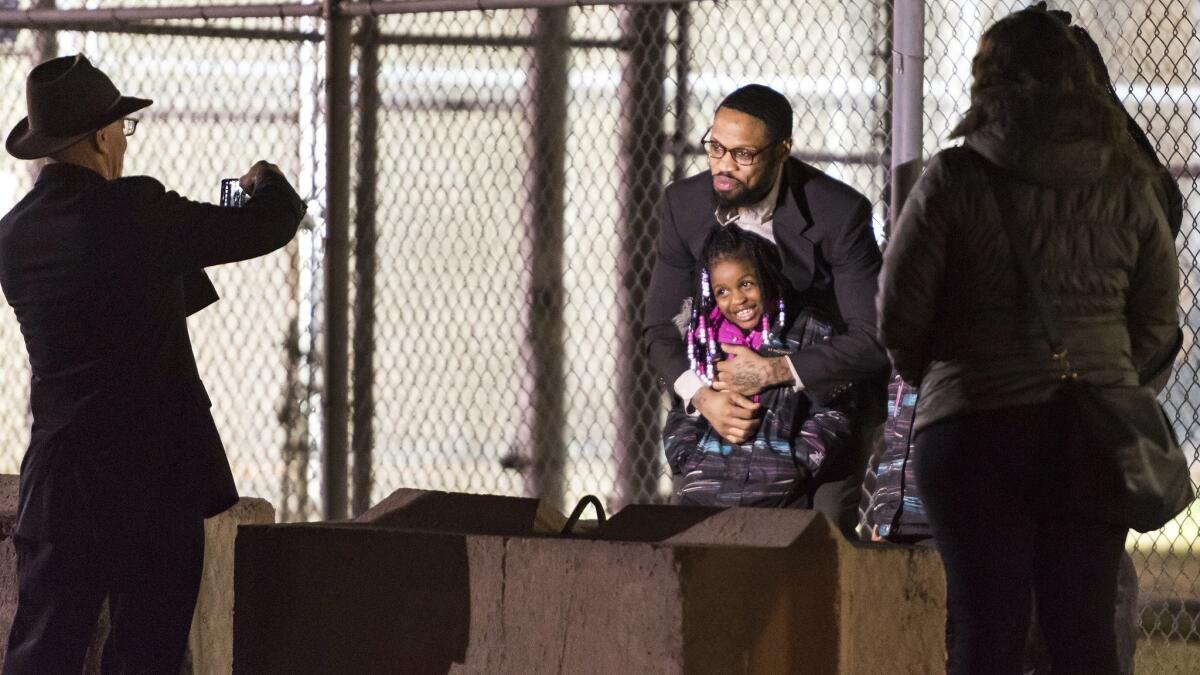 Isaiah McCoy hugs one of his daughters as he walks out of Howard R. Young Correctional Institution in Wilmington, Del., as a free man in January 2017.
