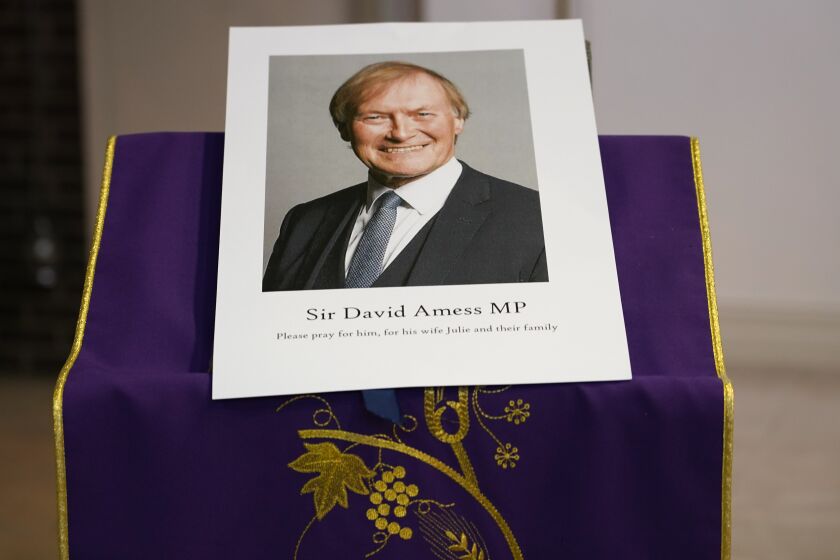 FILE - In this Friday, Oct. 15, 2021 file photo, an image of murdered British Conservative lawmaker David Amess is displayed near the altar in St Peters Catholic Church before a vigil in Leigh-on-Sea, Essex, England. British authorities say a man has been charged with murder and preparing acts of terrorism in the stabbing of a Conservative lawmaker who was killed as he met constituents at a church hall last week Police say Ali Harbi Ali, a 25-year-old British man with Somali heritage, has been charged in the death of David Amess. (AP Photo/Alberto Pezzali, File)