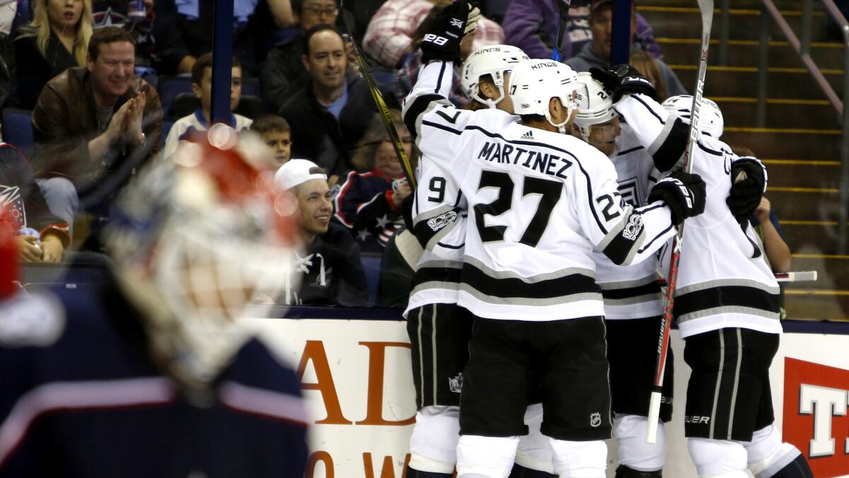 Kings players celebrate after scoring a goal against the Blue Jackets during the first period Saturday.