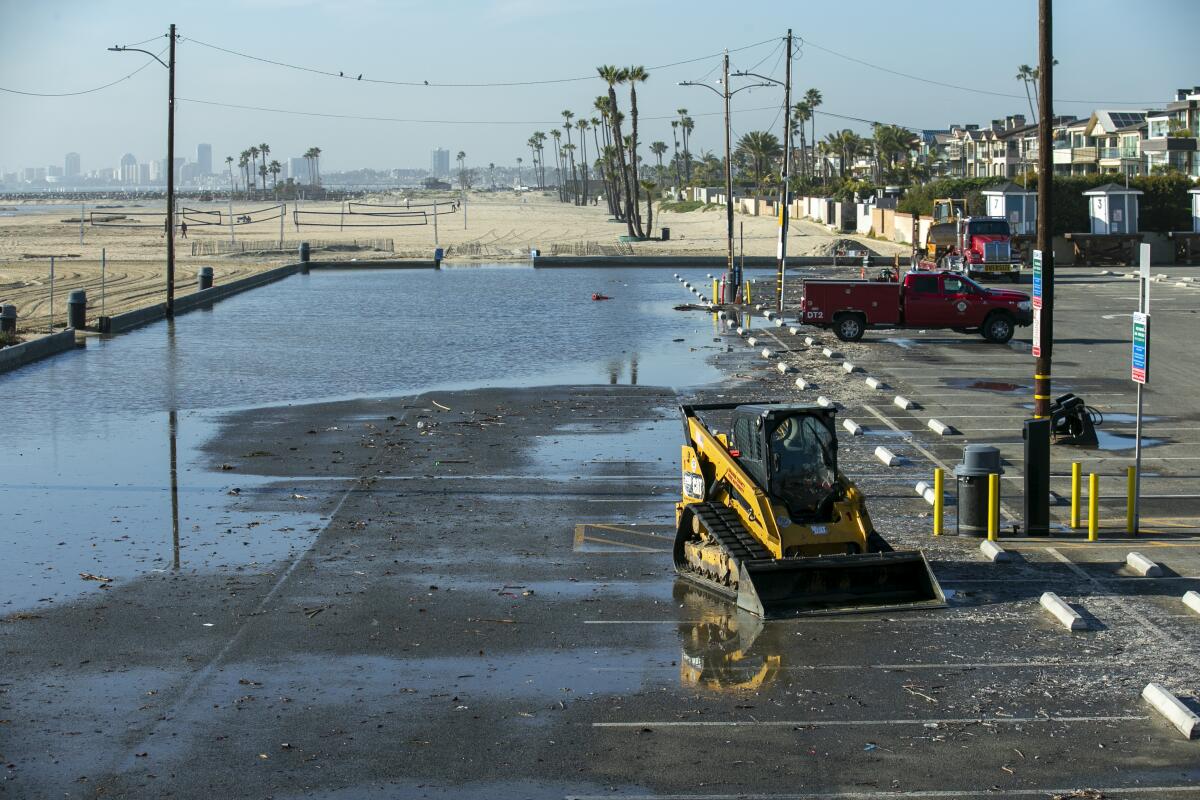  Standing water sits in the parking lot north of Seal Beach Pier on Friday.