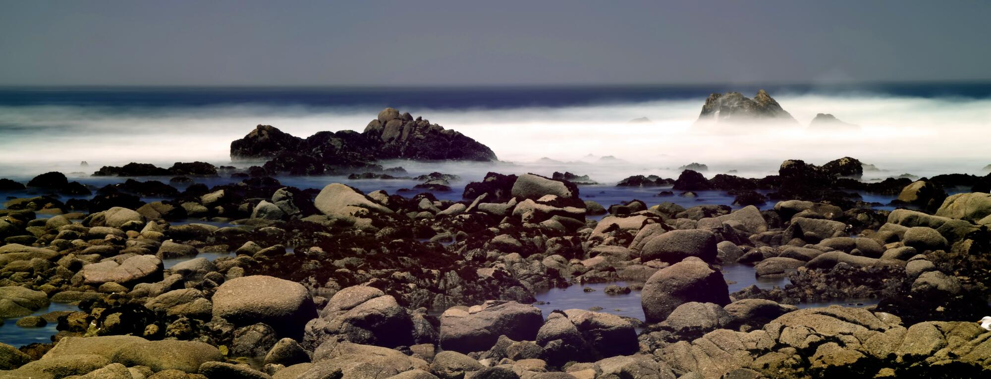 Rocks meet the ocean in an eerie-looking photo.