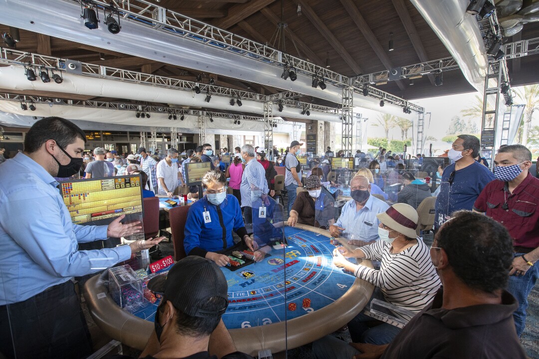 Photos: Closed for months, malls and casinos reopen in Los
Angeles County 5 Banker Fernando Martinez, left, looks at his hands before applying hand sanitizer at the Gardens Casino