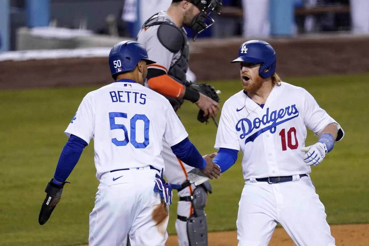 Justin Turner slaps hands with Mookie Betts.