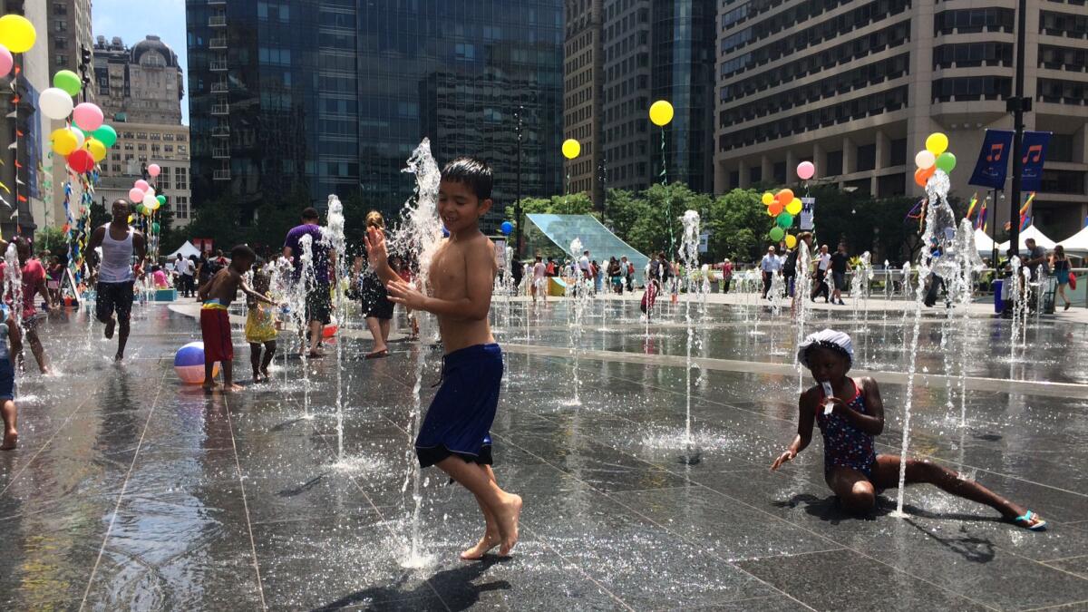 Children play in water fountains outside Philadelphia City Hall. (Matt Pearce / Los Angeles Times)