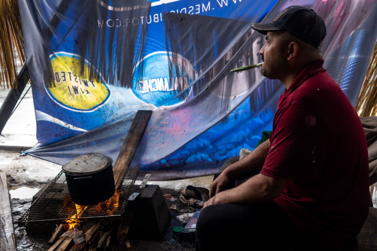 Reynaldo Roman cooks a pot of beans in his makeshift home on the streets.