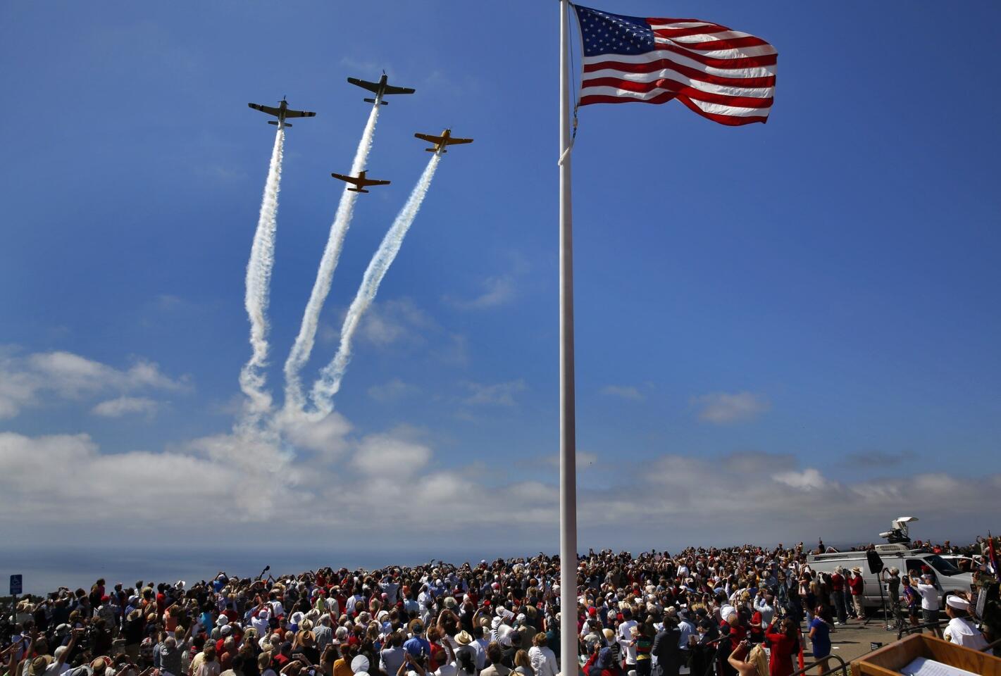 Four World War II-era T-34 planes fly over a crowd gathered at the Mt. Soledad Veterans Memorial in San Diego on Memorial Day.