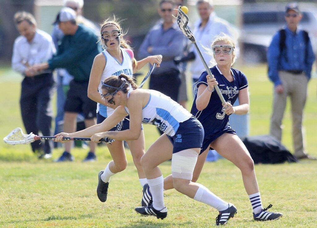 Newport Harbor High's Brittany McCoy, right, controls a loose ball against Corona del Mar's Emily Schwartz, center, and Jamie Smith, left, during the Battle of the Bay game on Friday.