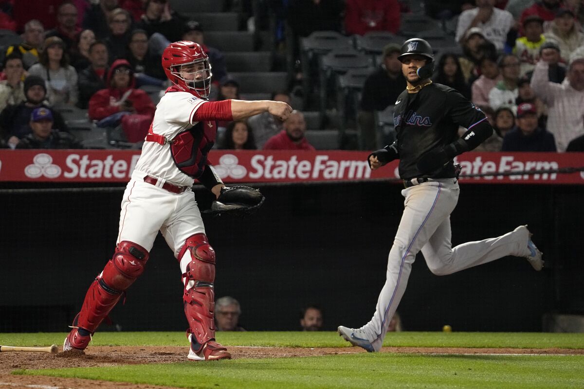 Miami's Yuli Gurriel, right, scores after Angels catcher Matt Thaiss failed to tag home plate.
