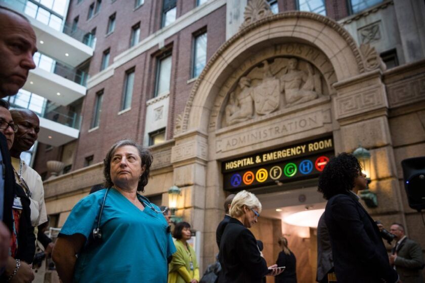 A nurse listens to a news conference about Ebola at Bellevue Hospital in New York City.