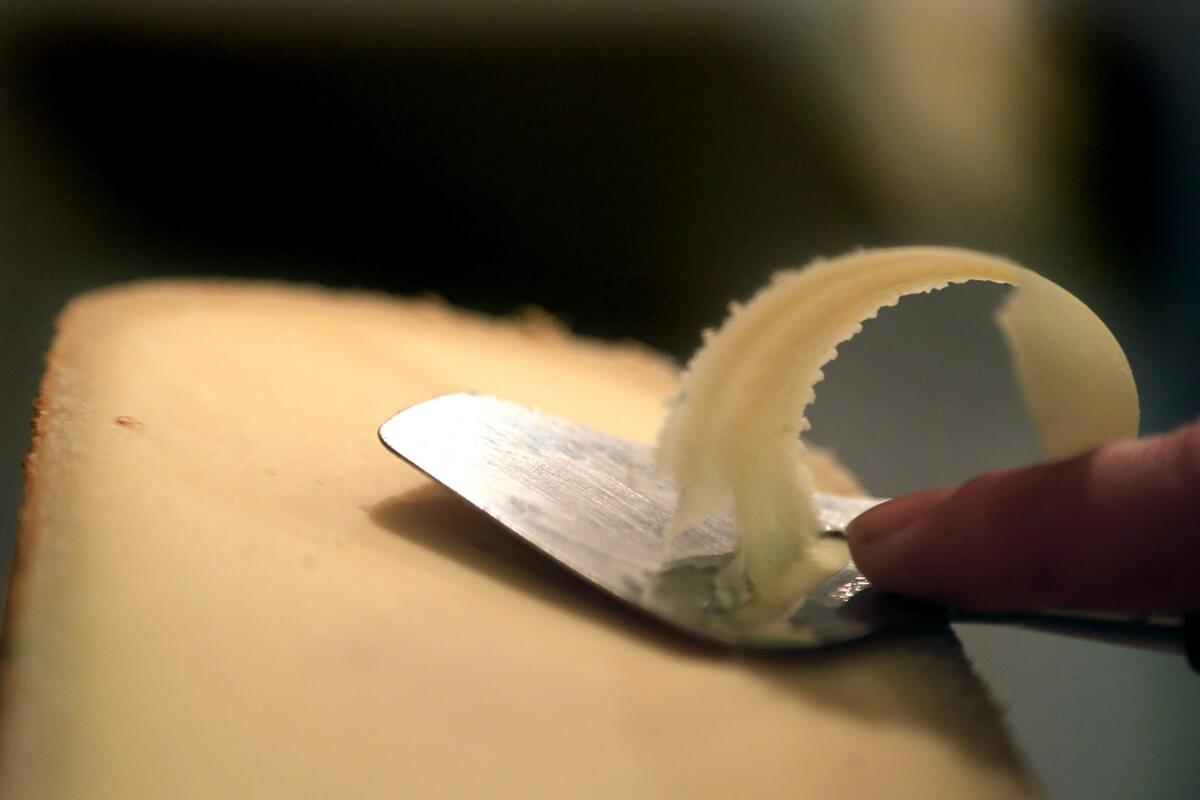 Lydia Clark shaves a piece of cheese for tasting at DTLA Cheese. 