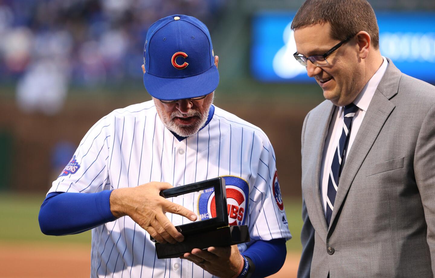Cubs manager Joe Maddon looks at his new jewelry as the team is presented with their 2016 world championship rings before a game against the Dodgers at Wrigley Field on Wednesday, April 12, 2017.