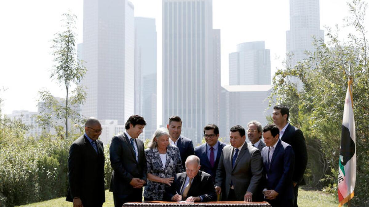 Gov. Jerry Brown and state legislators celebrate the passage of legislation to increase climate change goals in Los Angeles in 2016.