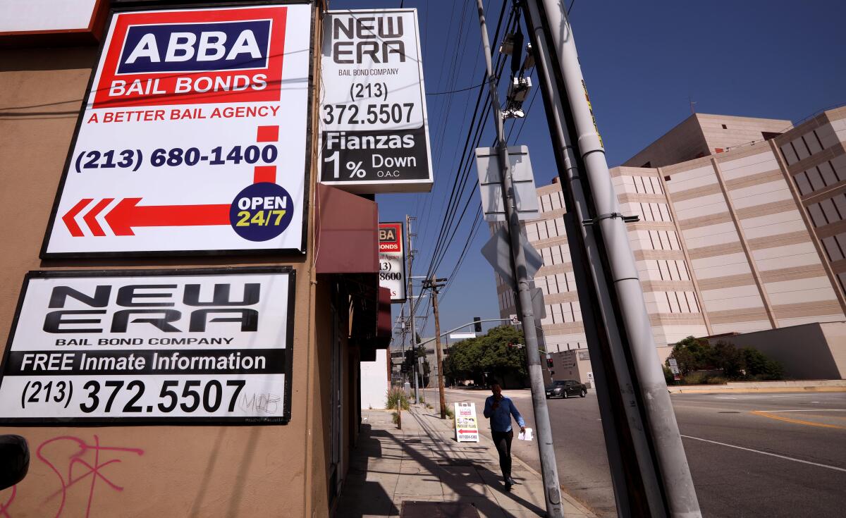 Signs advertising Abba Bail Bonds and New Era Bail Bond Co., down and across a city street from a large jail building