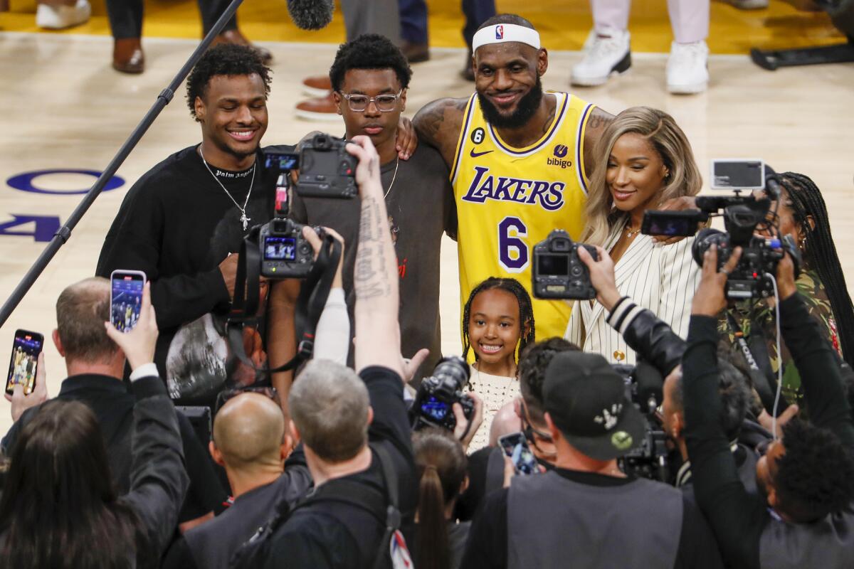LeBron James poses for photos with his family on the court after becoming the NBA's all-time scoring leader Tuesday night.