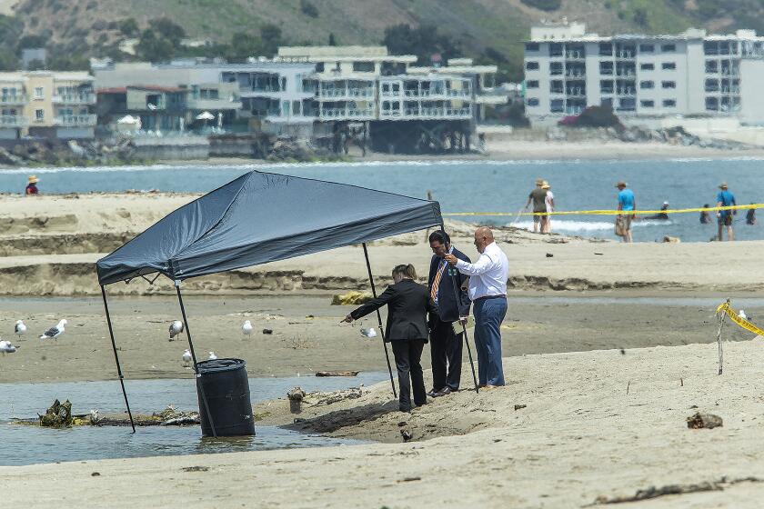MALIBU, CA-JULY 31, 2023: Members of the Los Angeles County Sheriff's Department investigate the scene at the Malibu Lagoon, where a body was found inside a 55-gallon drum. According to Lt. Hugo Reynaga of the L.A. County Sheriff's Dept., a lifeguard noticed the 55-gallon drum floating in the middle of the lagoon this morning and after getting it to shore and opening up the lld, discovered a lifeless human body inside. (Mel Melcon / Los Angeles Times)