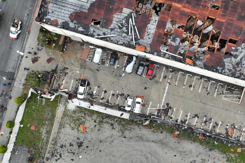 Montebello, CA - March 22: Crews start to clean up debris after a strong microburst -- which some witnesses dubbed a possible tornado -- heavily damaged several cars and buildings, including the roof of the Royal Paper Box Company, shown in photo, in Montebello Wednesday, March 22, 2023. Video from the scene showing portions of rooftops being ripped off industrial structures and debris swirling in the air. The National Weather Service on Tuesday night issued a brief tornado warning in southwestern Los Angeles County, but it was allowed to expire after about 15 minutes when weather conditions eased. There was no such warning in place late Wednesday morning when the powerful winds hit Montebello, near the area of Washington Boulevard and Vail Avenue. (Allen J. Schaben / Los Angeles Times)