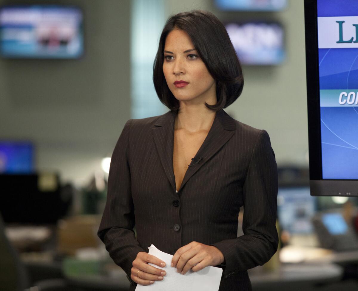 A female newscaster in a pinstripe suit prepares to tape a segment in "The Newsroom."