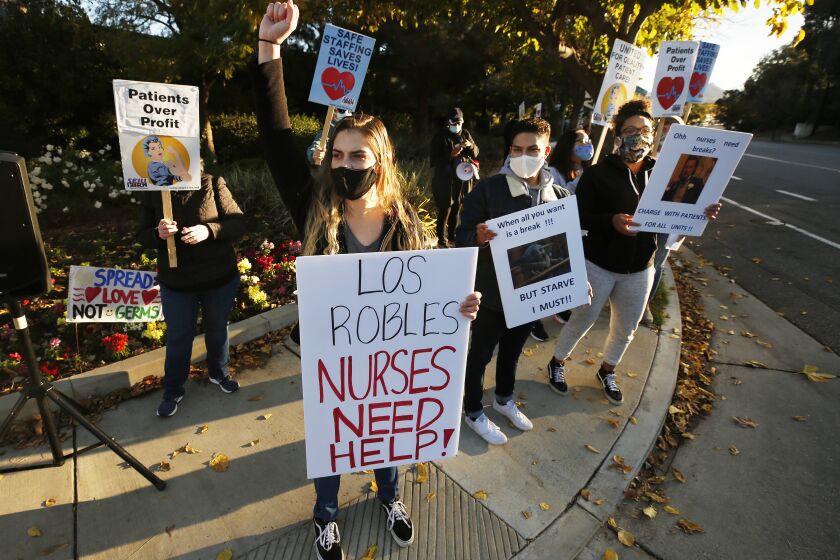 THOUSAND OAKS, CA - NOVEMBER 30: Registered Nurse Cianna Christopher, center, joins other nurses and licensed medical professionals Monday morning at Los Robles Regional Medical Center in Thousand Oaks as they picket in front of the hospital to raise concerns over "lack of COVID-19 testing for patients and staff, continued insufficient PPE and dangerous lack of staff on duty" as they sound the alarm on pandemic safety lapses inside the hospital. Los Robles Regional Medical Center on Monday, Nov. 30, 2020 in Thousand Oaks, CA. (Al Seib / Los Angeles Times
