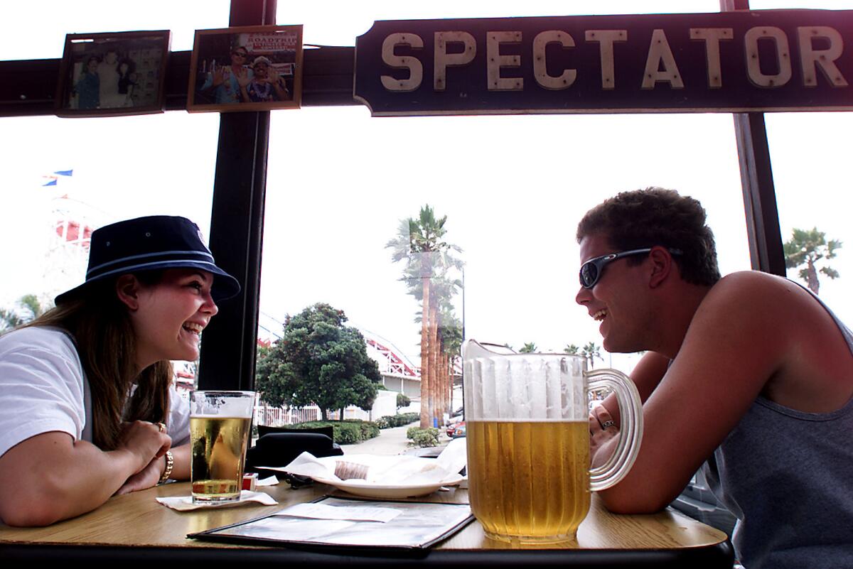 Arizona State University students Sarah Fluhr and Cody Hoge share a laugh at a pub in San Diego. The city is expected to be a top travel destination for Memorial Day weekend.