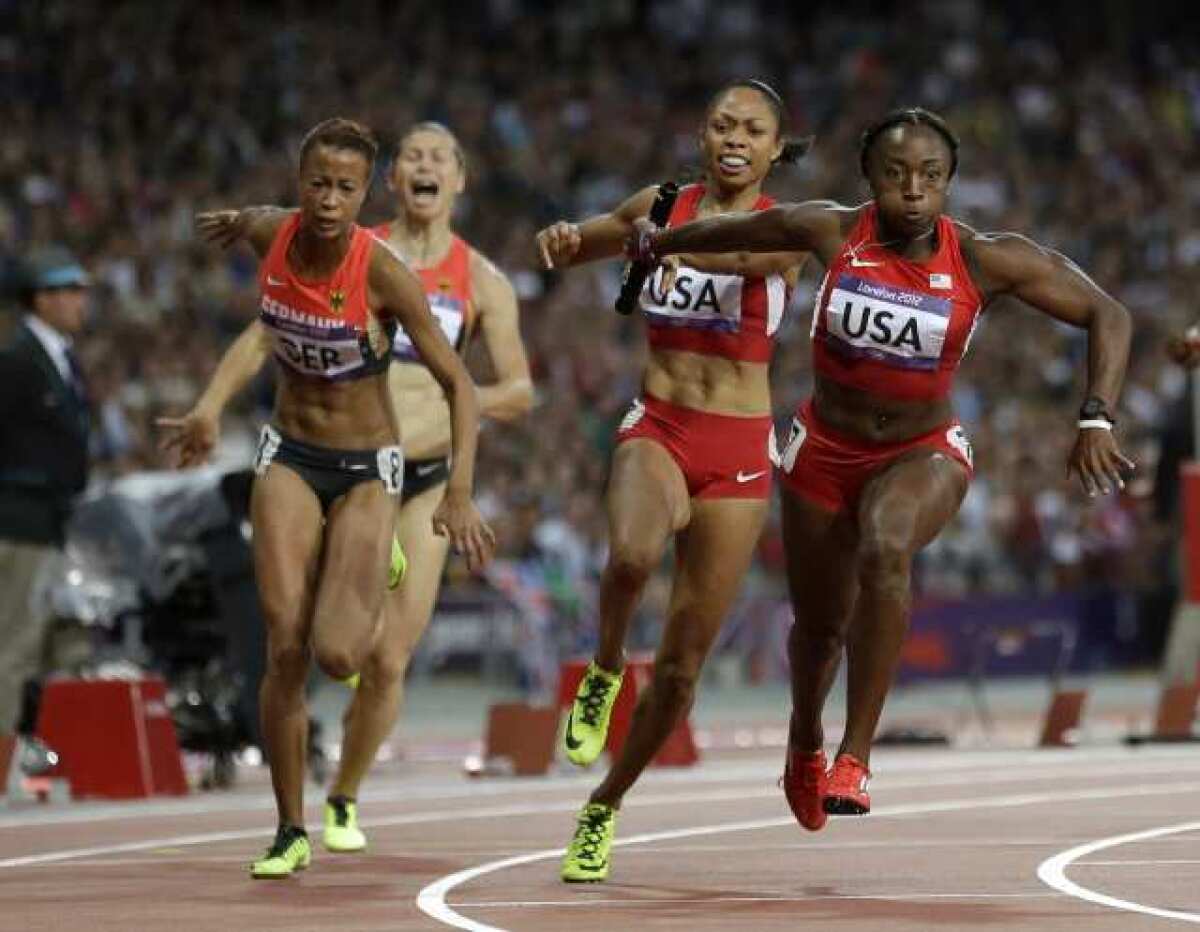 Bianca Knight, right, takes the baton from U.S. teammate Allyson Felix in the women's 400-meter relay final.