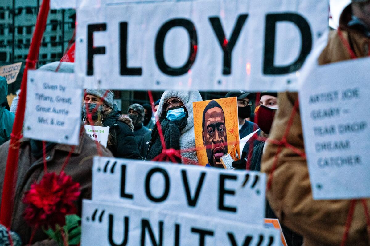 Protesters carry signs in support of George Floyd in downtown Minneapolis