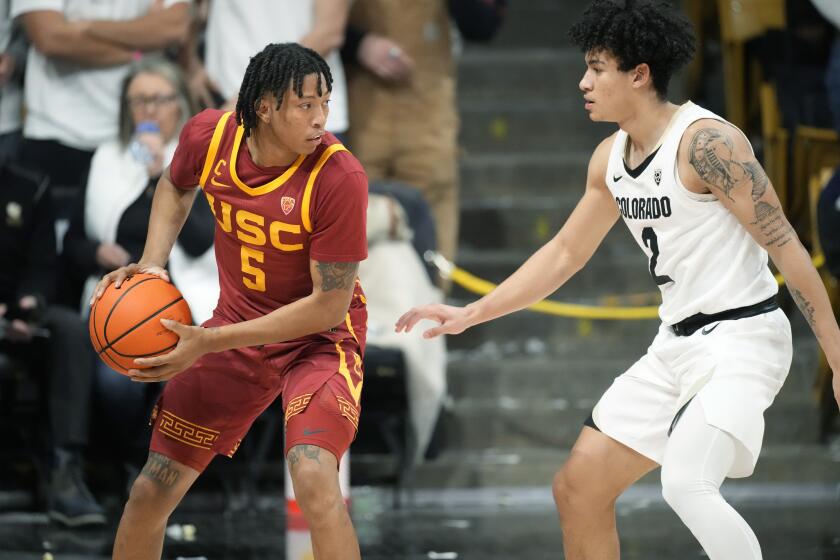 Southern California guard Boogie Ellis, left, looks to pass the ball as Colorado guard KJ Simpson defends in the second half of an NCAA college basketball game Thursday, Feb. 23, 2023, in Boulder, Colo. (AP Photo/David Zalubowski)