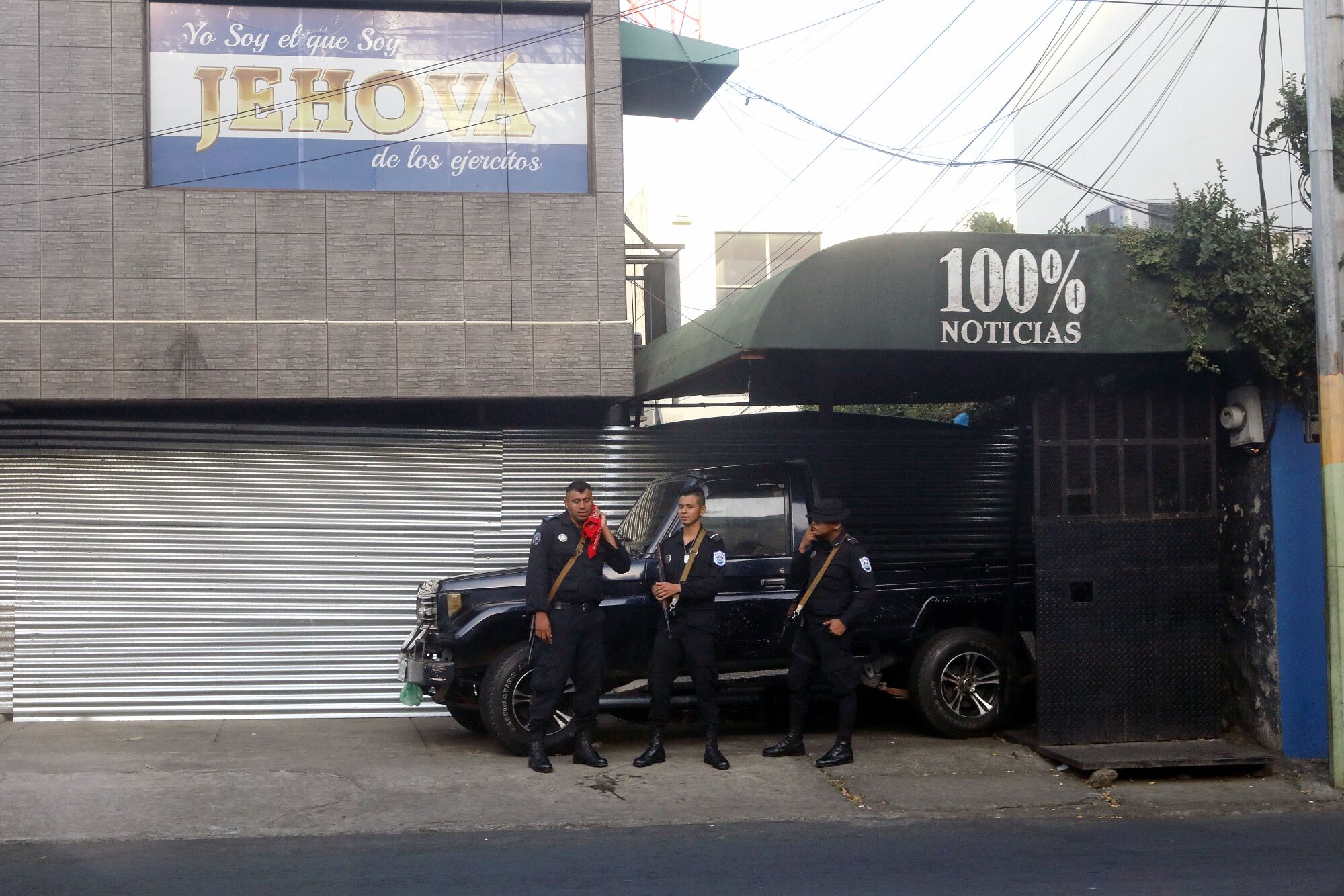 Nicaraguan police stand guard outside the news channel 100% Noticias, which was shut down by the government in 2018.
