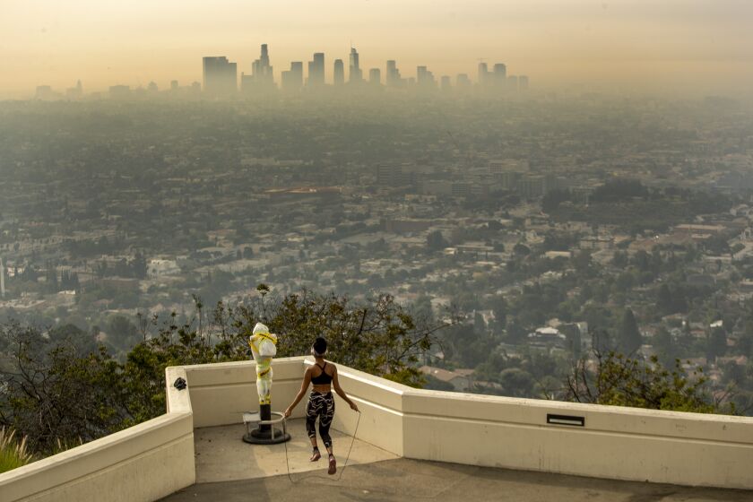 LOS ANGELES, CA - SEPTEMBER 17: Los Angeles resident Carmen Green jumps rope at a closed Griffith Observatory where she found a quiet nook to exercise in spite of dense smoke from Southern California wildfires choking the L.A. Basin on Thursday, Sept. 17, 2020 in Los Angeles, CA. (Brian van der Brug / Los Angeles Times)