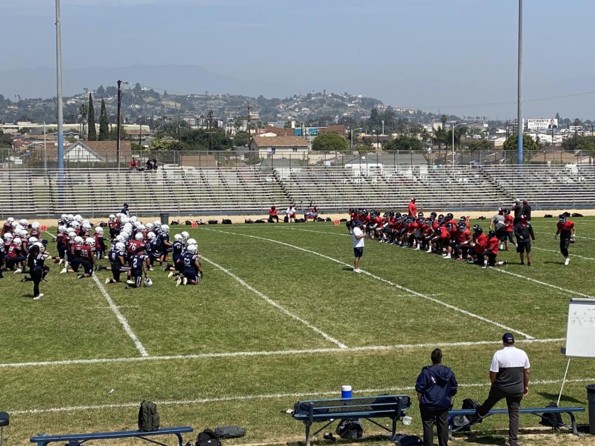 Players for Garfield, left, and Banning gather before Saturday's scrimmage.