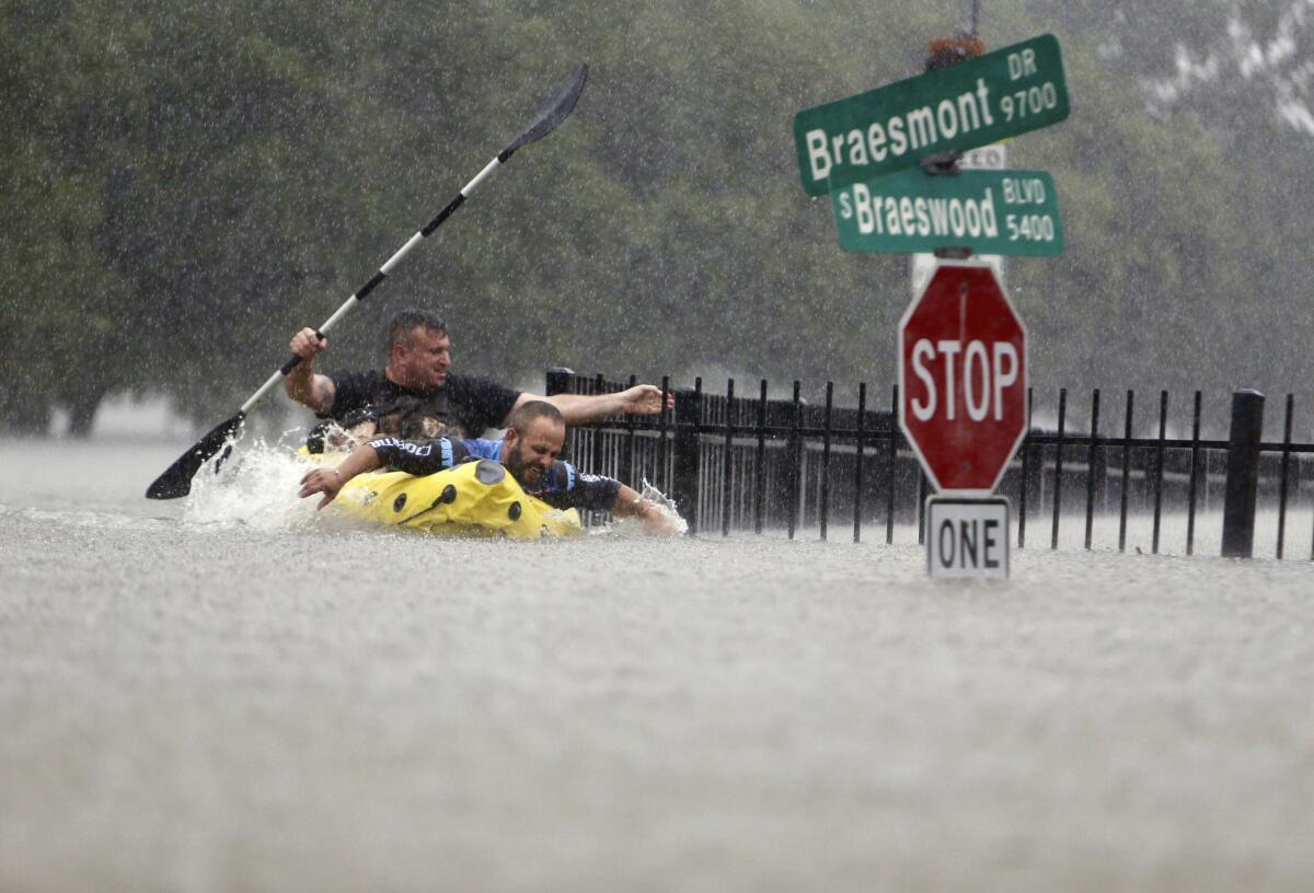 Two kayakers try to beat the current pushing them down an overflowing Brays Bayou along South Braeswood Boulevard in Houston. (Mark Mulligan / Houston Chronicle)