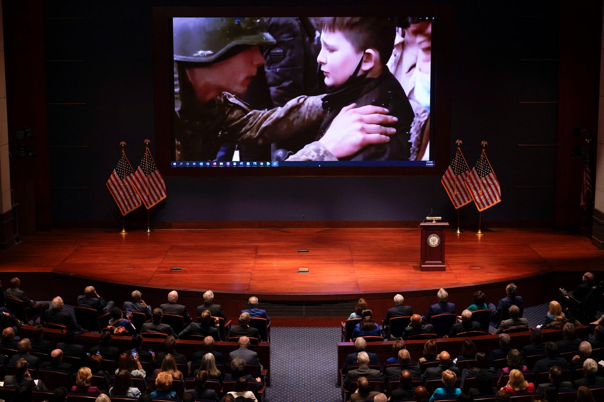 A screen shows a soldiers on a young boy's shoulders.