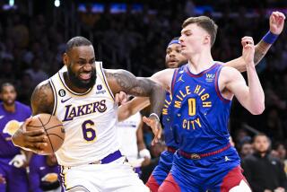 Lakers forward LeBron James winces as he drives to the basket in front of Nuggets guard Christian Braun 