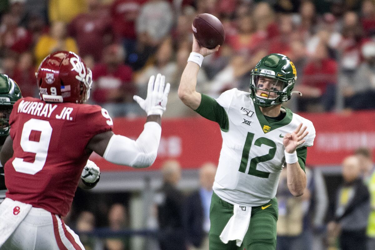 File-Baylor quarterback Charlie Brewer (12) throws past the defense of Oklahoma linebacker Kenneth Murray (9) during the first half of an NCAA college football game for the Big 12 Conference championship, Saturday, Dec. 7, 2019, in Arlington, Texas. Brewer never spent a lot of time thinking about how beat up he was at the end of last season after a tough finish for the Bears. But he just might slide a little more in his fourth season as Baylor starter, when the Big 12 runner-up Bears hope to get a step farther with a new coach coming off a national championship. (AP Photo/Jeffrey McWhorter, File)