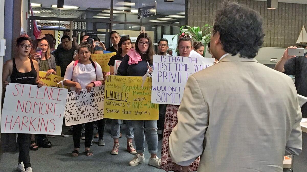 Protesters ask Madjid Niroumand, OCC's vice president of student services, why the college hasn't taken action against the Republicans Club.