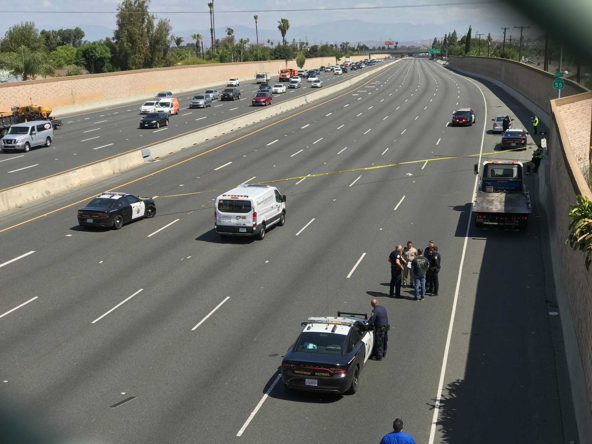 Law enforcement officials examine the scene on the northbound 55 Freeway after Aiden Leos was fatally shot on May 21.
