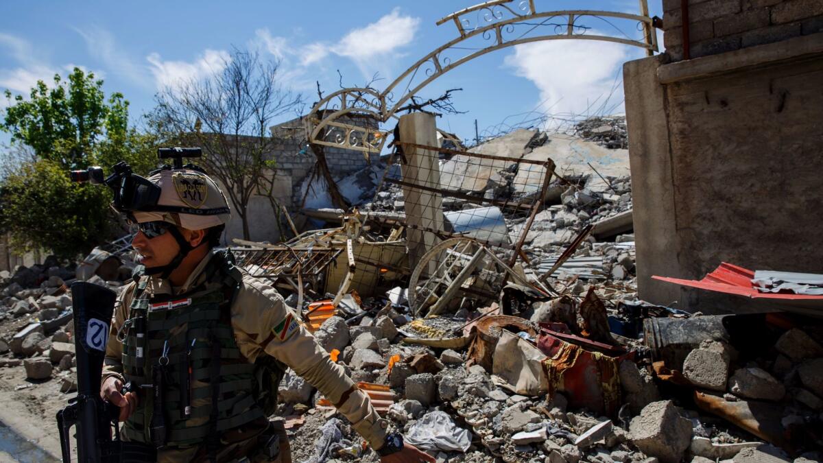 An Iraqi soldier stands outside Omar Hasan Abdul Qadir's home, which was destroyed in an airstrike in the Baysan neighborhood of Mosul, Iraq.