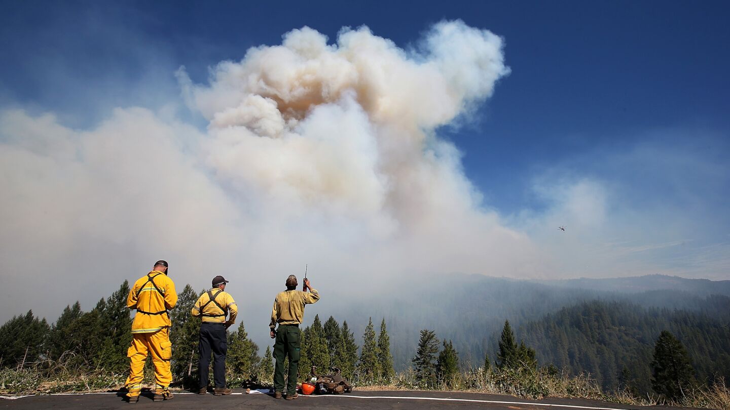 Firefighters monitor the King fire on Wednesday in Pollock Pines, Calif.