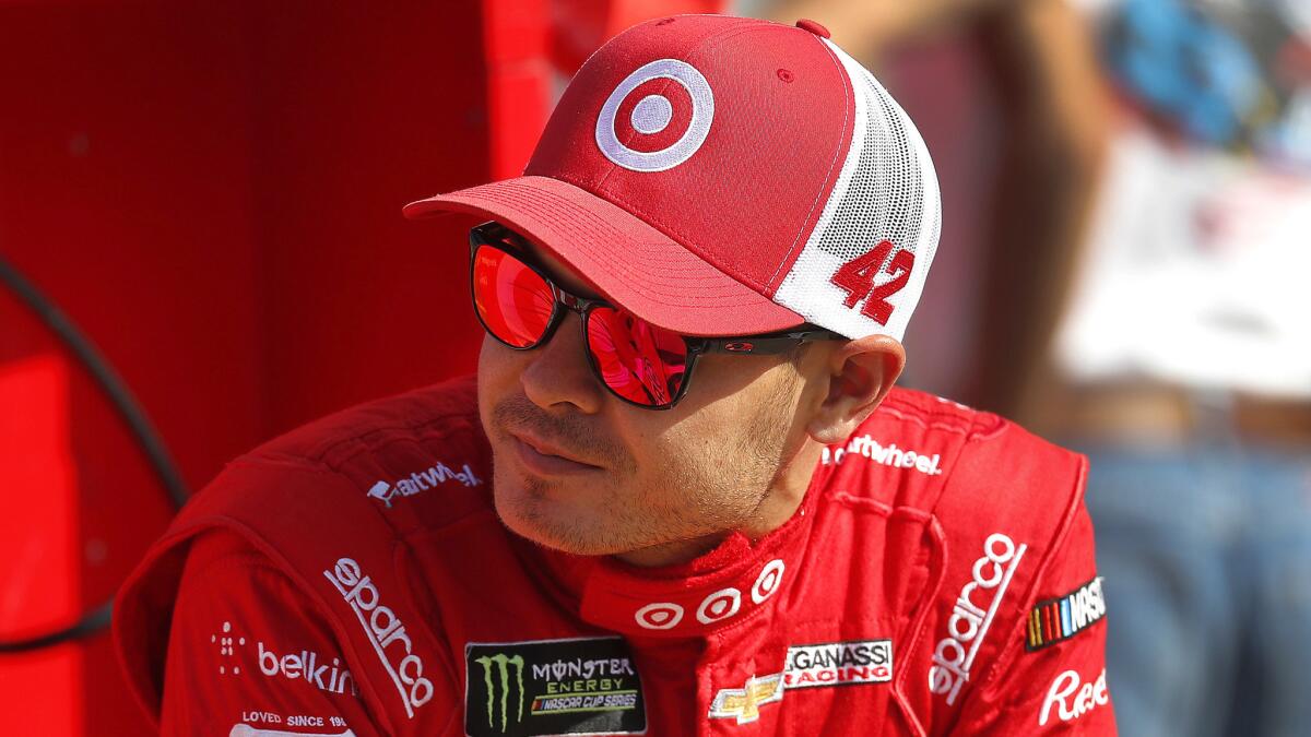 Kyle Larson talks with teammates prior to qualifying for the NASCAR Cup Series auto race in Brooklyn, Mich., Friday, Aug. 11, 2017. (AP Photo/Paul Sancya)