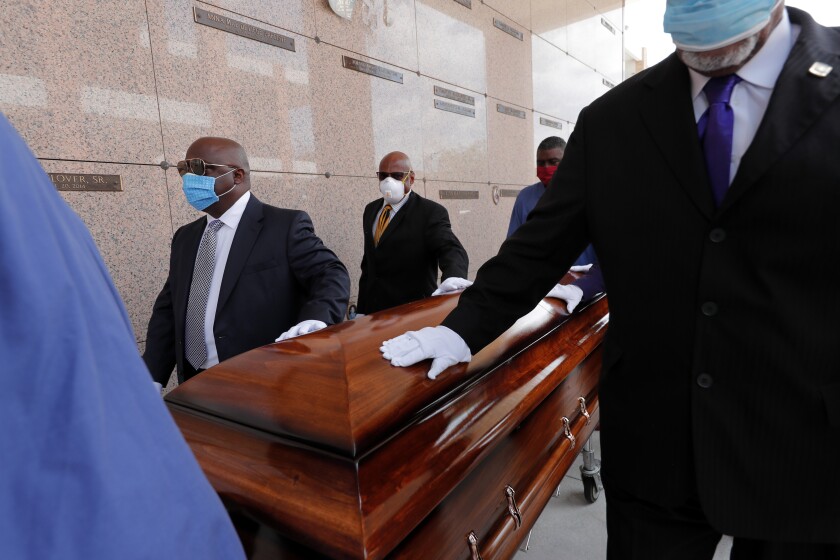  In this April 22, 2020 photo, pallbearers walk the casket of Larry Hammond who died from the coronavirus