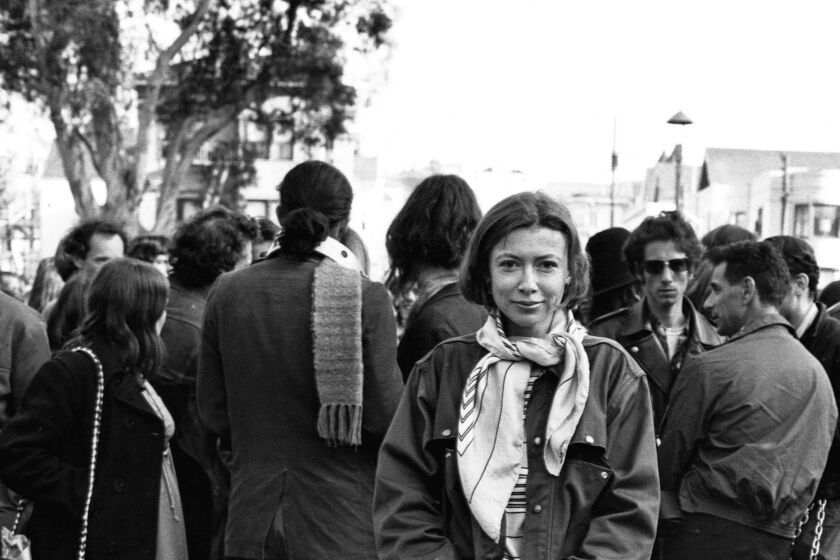 Writer Joan Didion stands at the panhandle of Golden Gate Park with a group of hippies during the writing of her article "Slouching Towards Bethlehem." April 1967.