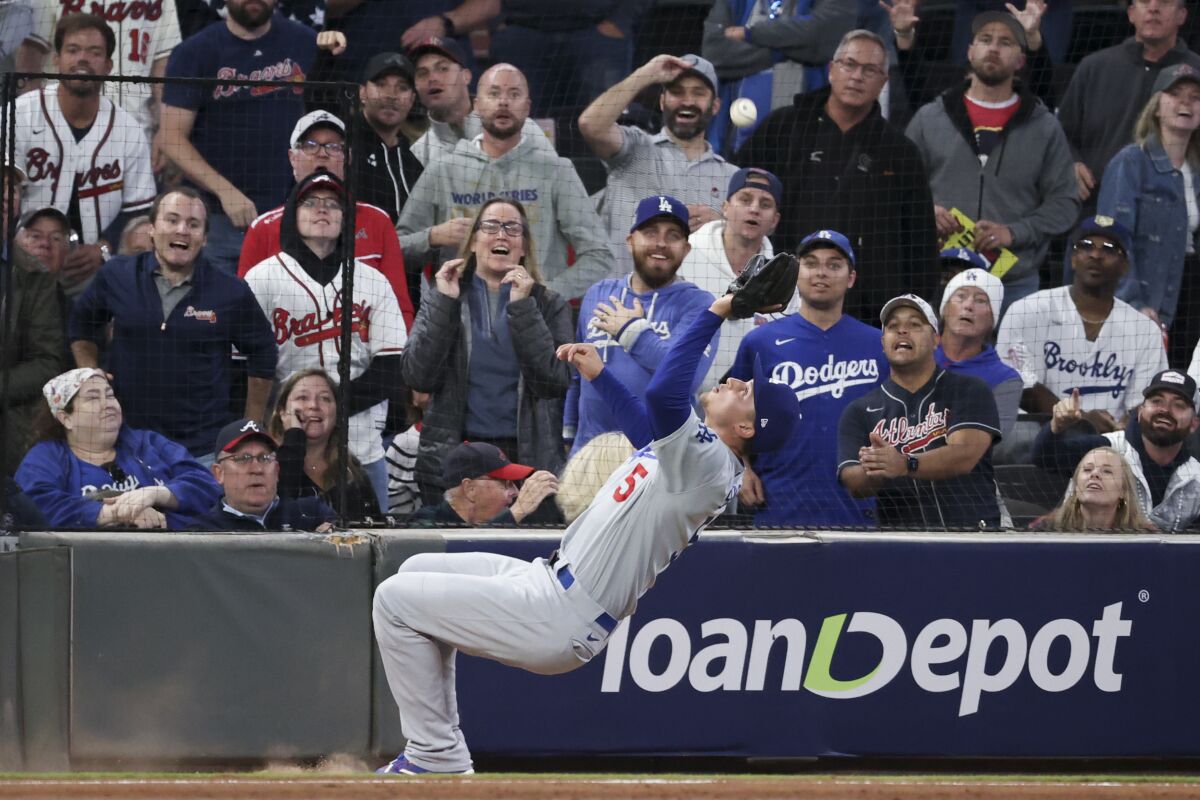 Dodgers shortstop Corey Seager leans near the stands to catch a pop up fly by Atlanta Braves' Joc Pederson.