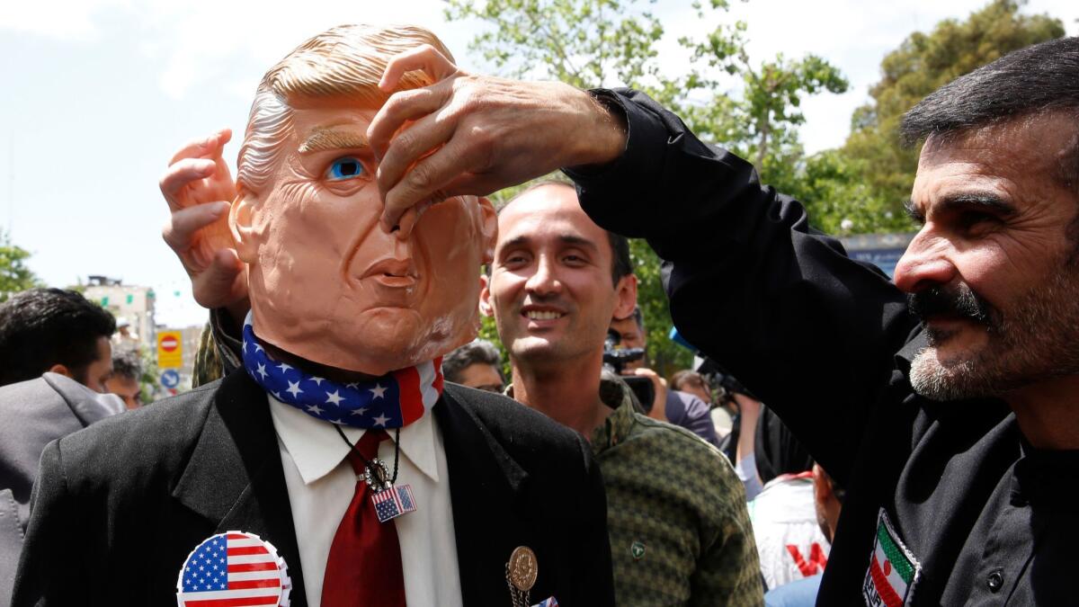 Demonstrators stand around an Iranian man wearing a President Trump mask during an anti-U.S. rally in Tehran on May 10.